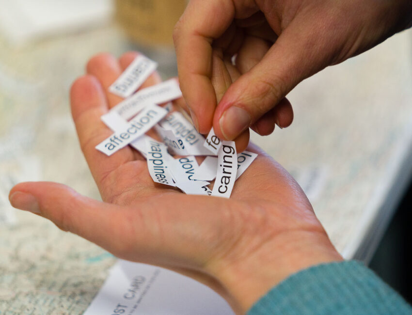 A close up of a hand holding a pile of cut up words.