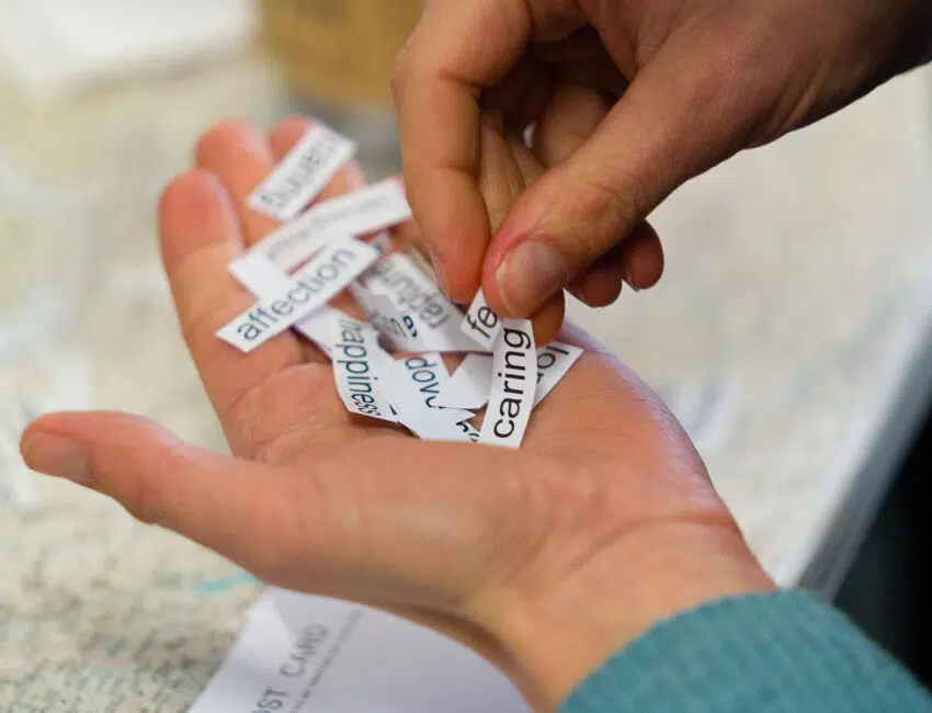 A close up of a hand holding a pile of cut up words.